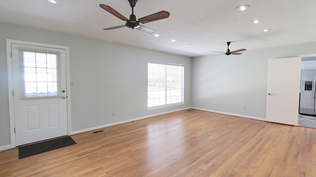 interior space featuring visible vents, baseboards, light wood-style floors, and a ceiling fan