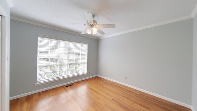 unfurnished room with visible vents, light wood-style flooring, baseboards, and ornamental molding