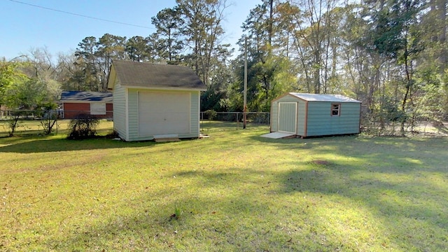 view of yard with an outdoor structure, fence, and a shed