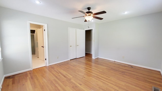 unfurnished bedroom featuring visible vents, baseboards, ensuite bath, ceiling fan, and light wood-style floors