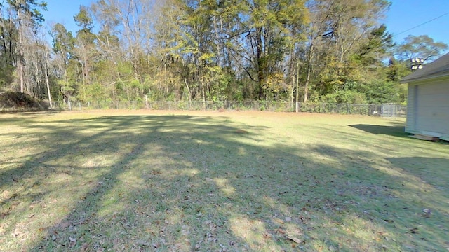 view of yard with a forest view and a fenced backyard