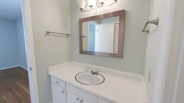 bathroom with wood finished floors, a chandelier, and vanity