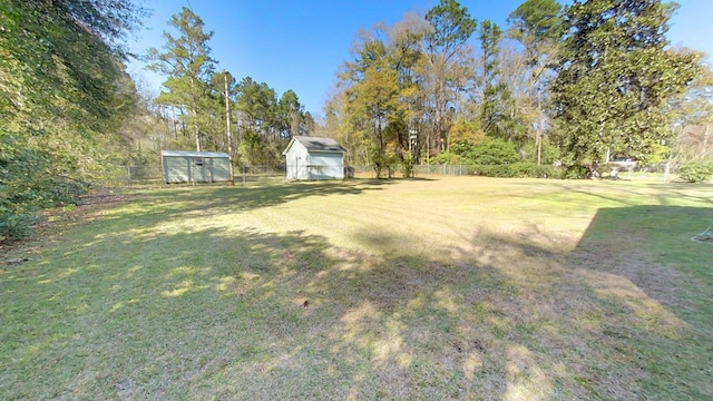 view of yard with an outbuilding, fence, and a shed