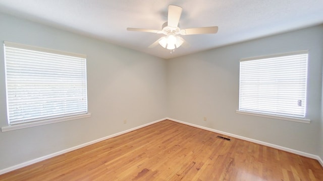 spare room with visible vents, baseboards, ceiling fan, and light wood finished floors