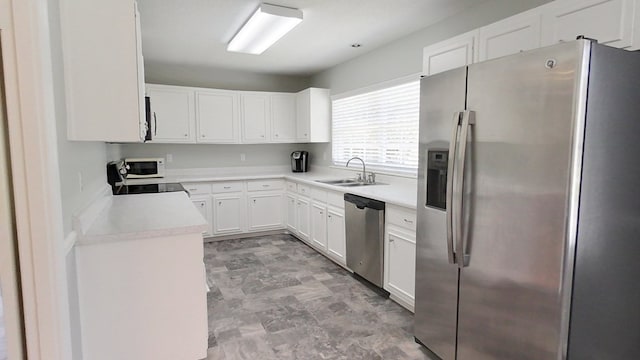 kitchen featuring a sink, stainless steel appliances, white cabinets, and light countertops