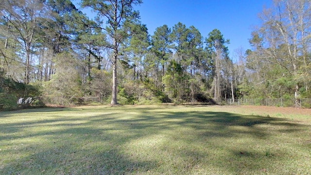 view of yard with a view of trees and fence