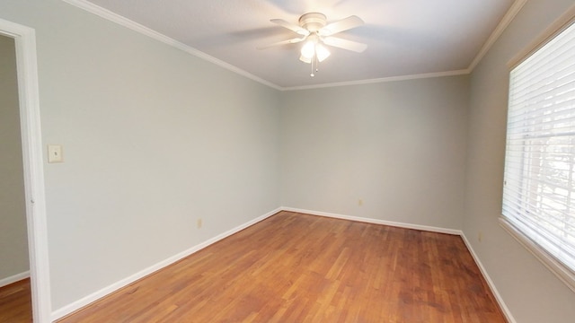 spare room featuring light wood-type flooring, baseboards, ornamental molding, and a ceiling fan