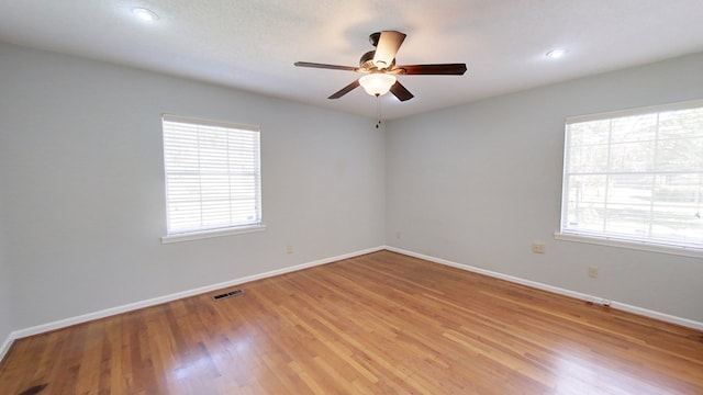 unfurnished room with visible vents, baseboards, light wood-style floors, and ceiling fan