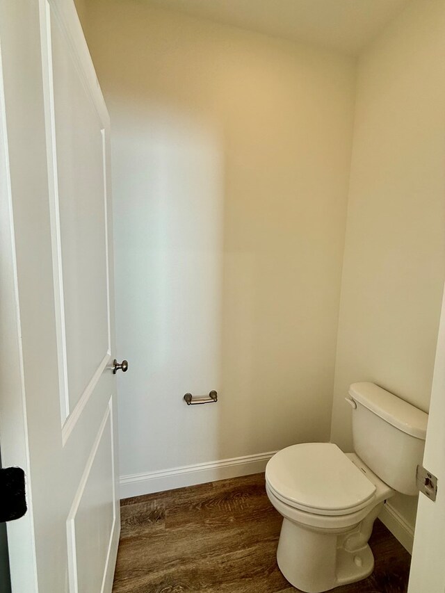 bathroom with hardwood / wood-style flooring and toilet