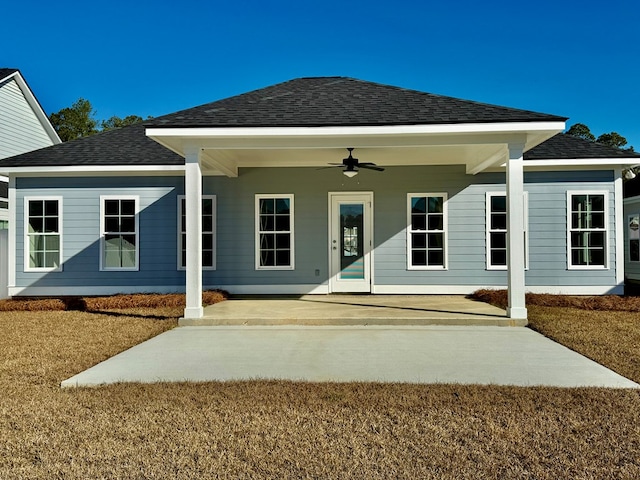 rear view of house with a patio, ceiling fan, and a lawn