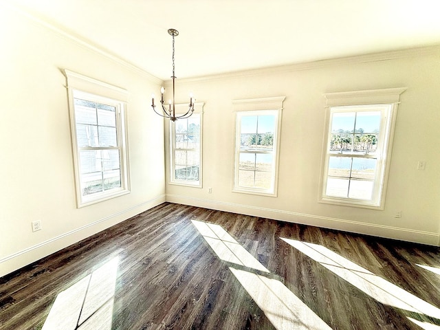 unfurnished dining area with a notable chandelier, crown molding, dark wood-type flooring, and a healthy amount of sunlight