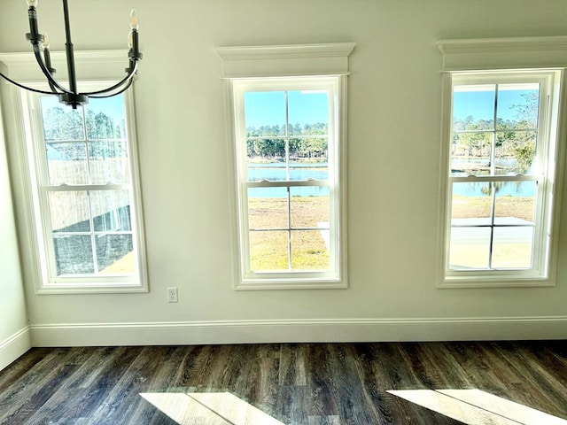 unfurnished dining area with a water view and dark hardwood / wood-style floors