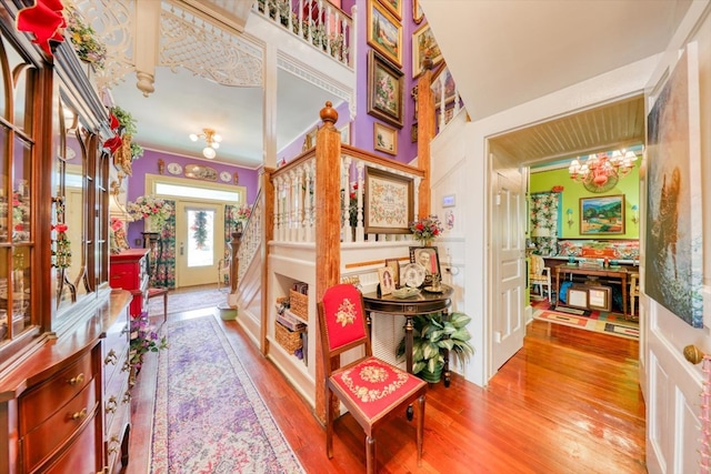 interior space featuring hardwood / wood-style flooring, crown molding, and a chandelier