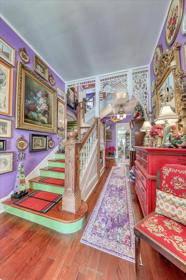 staircase featuring a chandelier and hardwood / wood-style floors