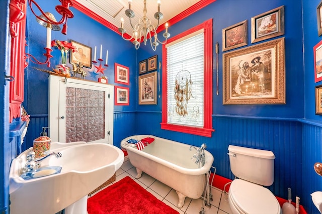 bathroom with a tub, sink, toilet, tile patterned floors, and an inviting chandelier