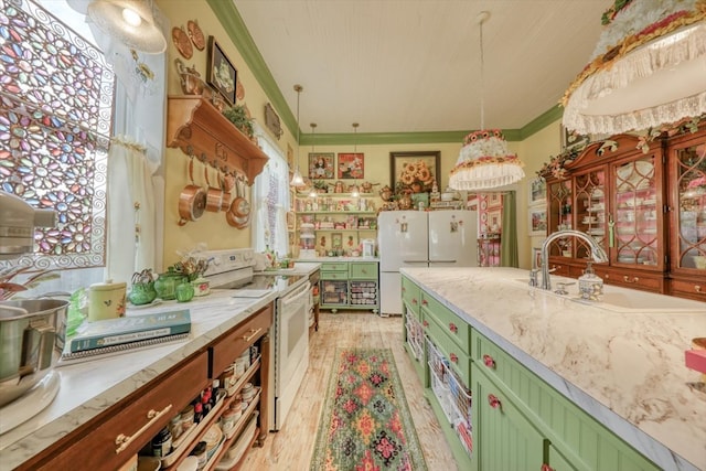 kitchen with sink, light stone counters, crown molding, decorative light fixtures, and white appliances