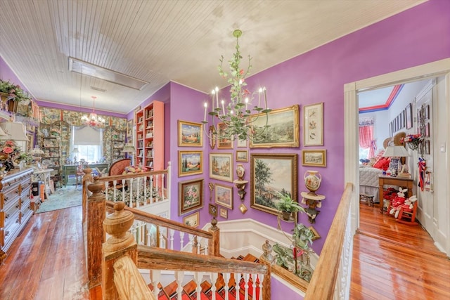 stairs featuring crown molding, hardwood / wood-style floors, and a chandelier