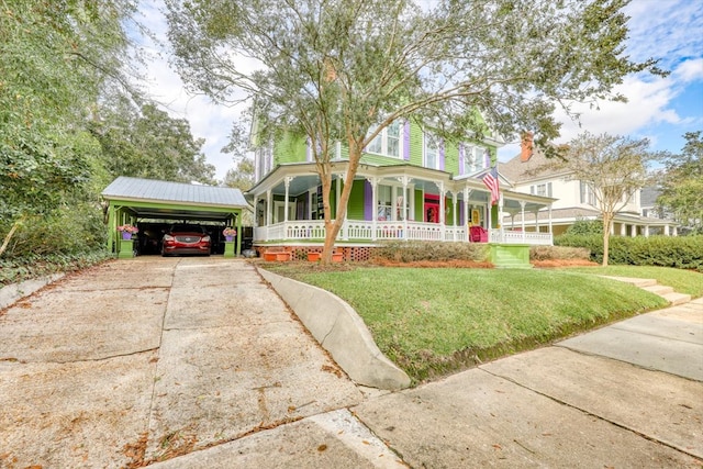 victorian house featuring a carport, covered porch, and a front yard