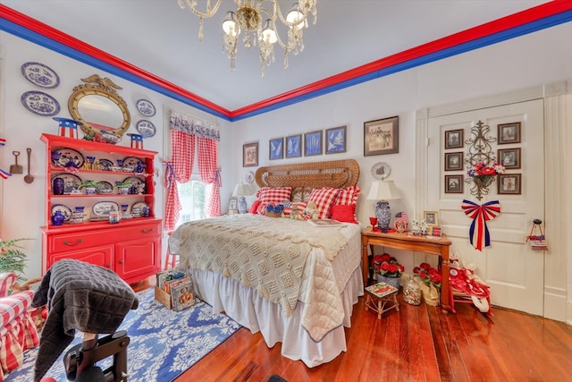 bedroom featuring hardwood / wood-style floors, a notable chandelier, and ornamental molding