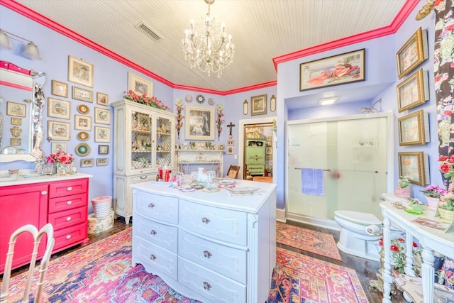 interior space with toilet, a shower with shower door, crown molding, a chandelier, and hardwood / wood-style floors