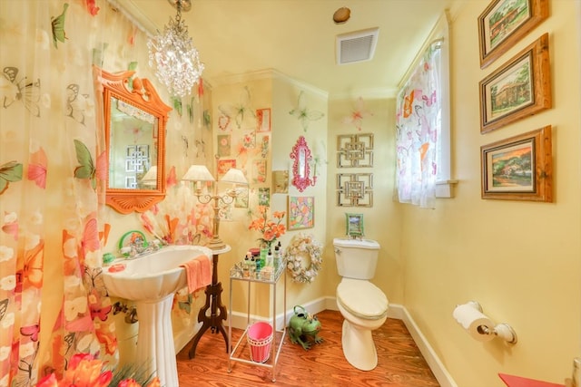 bathroom featuring ornamental molding, toilet, and hardwood / wood-style floors