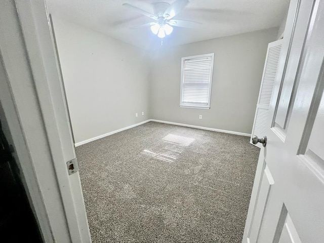 unfurnished room with ceiling fan and carpet floors