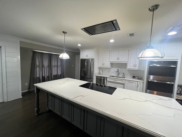 kitchen featuring sink, decorative light fixtures, white cabinets, and appliances with stainless steel finishes