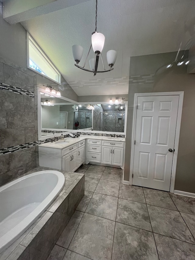 bathroom with shower with separate bathtub, vaulted ceiling, a textured ceiling, vanity, and a notable chandelier