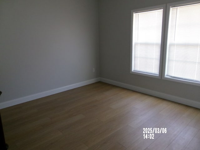 empty room featuring baseboards and wood finished floors