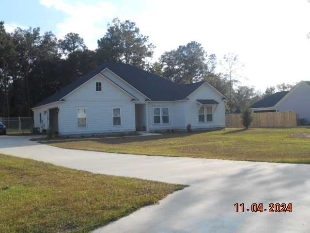 view of front of home with driveway, a front yard, and fence