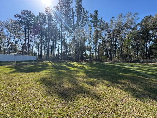 view of side of property with fence and a lawn