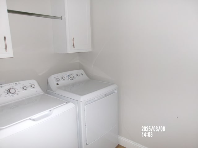 clothes washing area featuring cabinet space and independent washer and dryer