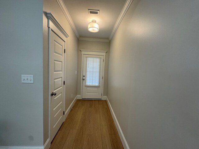 dining room with ornamental molding, light wood-style floors, and baseboards