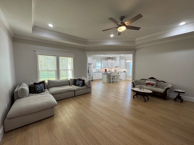 kitchen with appliances with stainless steel finishes, white cabinetry, crown molding, and wall chimney range hood