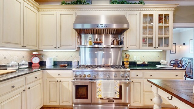 1017 Rowland Rd, Boston, GA 31626 - kitchen with double oven range, cream cabinets, wall chimney exhaust hood, tasteful backsplash, and crown molding