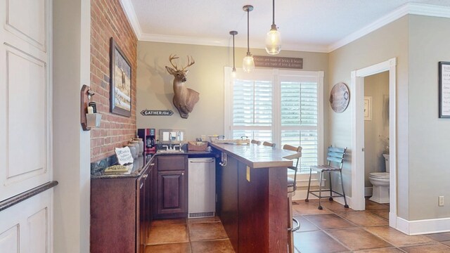 1017 Rowland Rd, Boston, GA 31626 - kitchen with ornamental molding, a peninsula, pendant lighting, tile patterned flooring, and a kitchen breakfast bar
