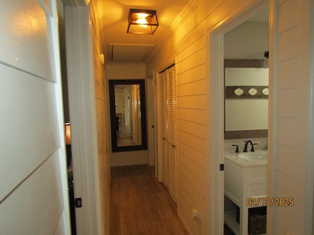 corridor featuring ornamental molding, sink, and hardwood / wood-style floors