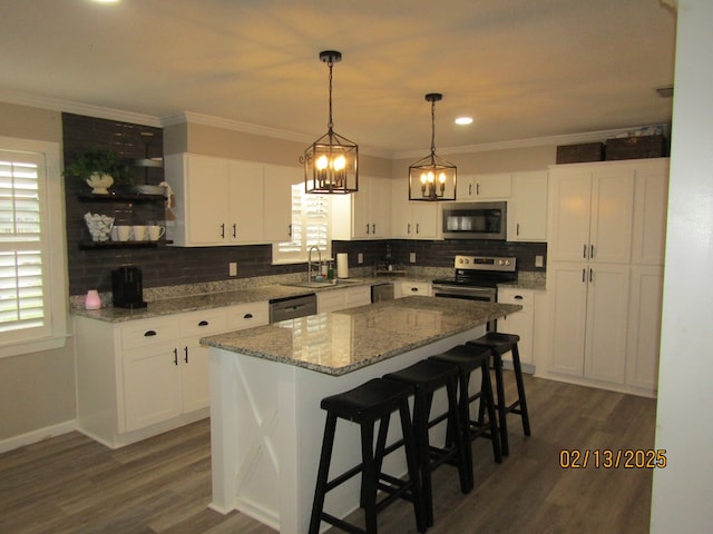 kitchen featuring white cabinetry, appliances with stainless steel finishes, sink, and a kitchen island