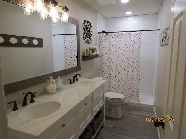 bathroom featuring hardwood / wood-style flooring, vanity, curtained shower, and toilet