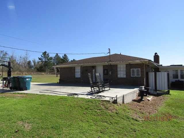 rear view of property with a lawn and a patio