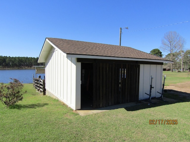 view of outbuilding featuring a water view and a yard