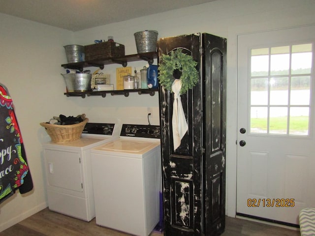 laundry room with wood-type flooring, independent washer and dryer, and a healthy amount of sunlight