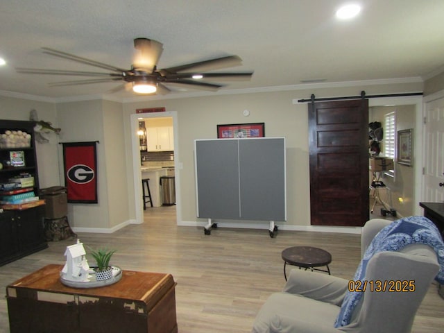 living room with crown molding, a barn door, and light wood-type flooring