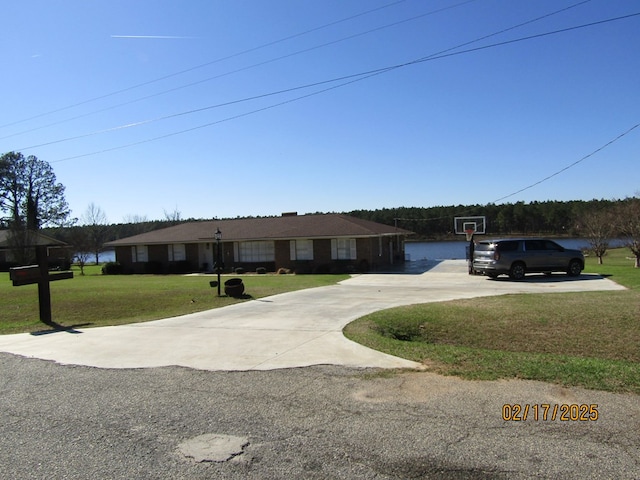 view of front of home featuring basketball hoop and a front lawn