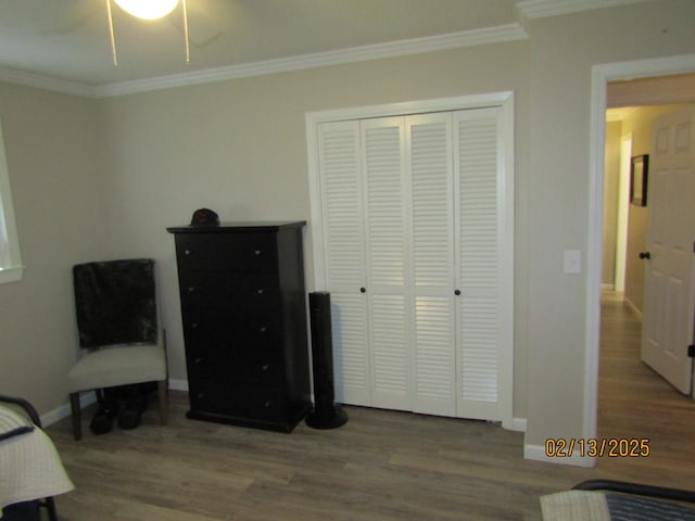 bedroom with wood-type flooring, ornamental molding, and a closet