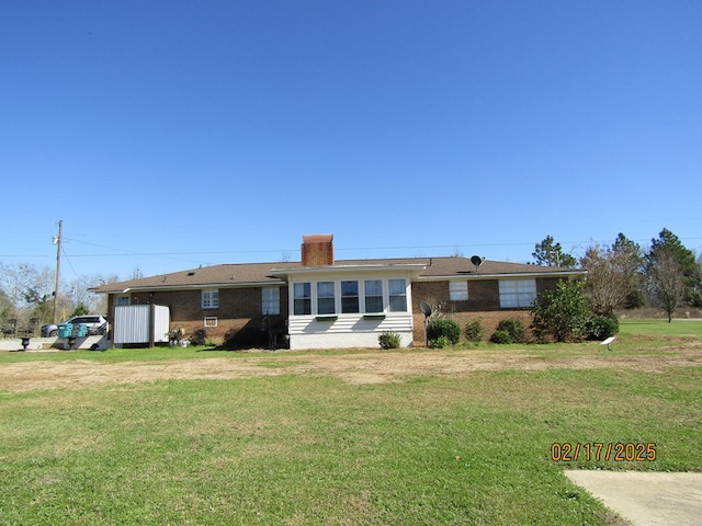 rear view of house featuring a lawn