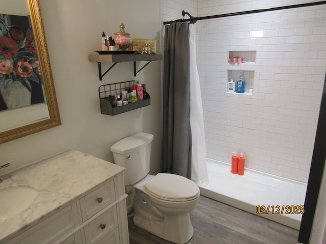 bathroom with hardwood / wood-style floors, vanity, a shower with shower curtain, and toilet