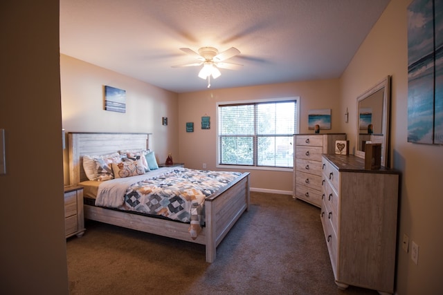 bedroom featuring ceiling fan and dark carpet