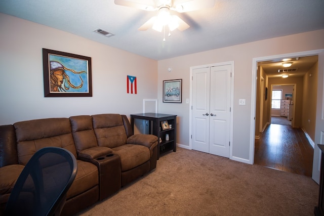 carpeted living room featuring a textured ceiling and ceiling fan