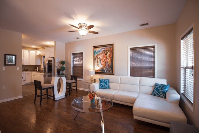 living room featuring ceiling fan and dark hardwood / wood-style floors